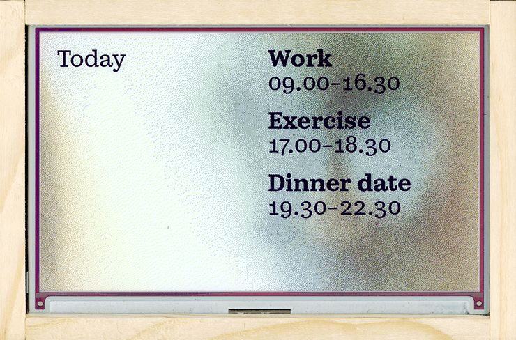 E-ink display in wooden frame displaying a daily agenda over a nice green dithered image.